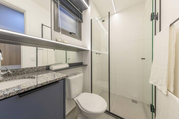 Banheiro da suíte do Brisas Bella Città com acabamentos modernos.